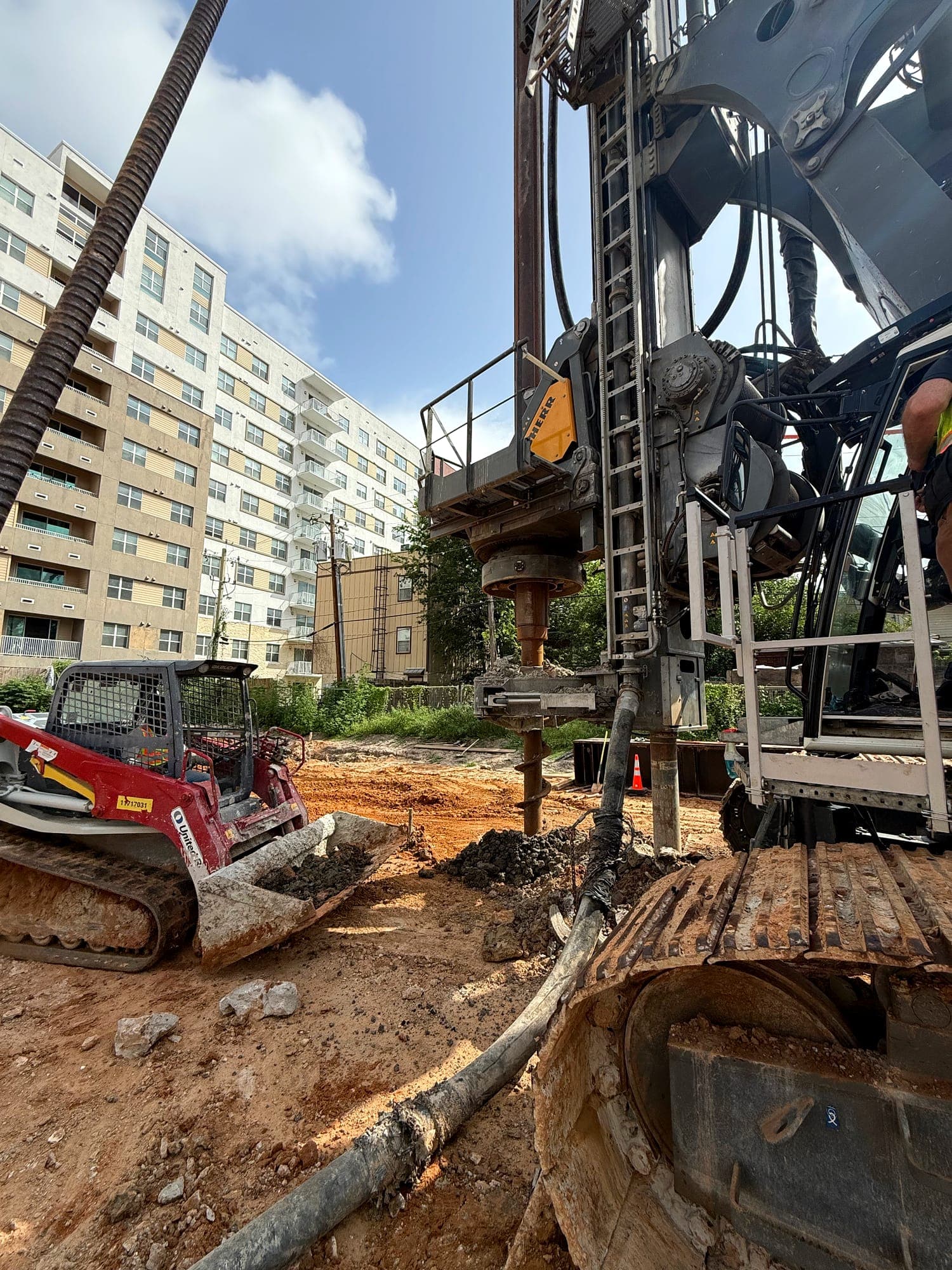 Drilling rig installing pier foundations on an urban site