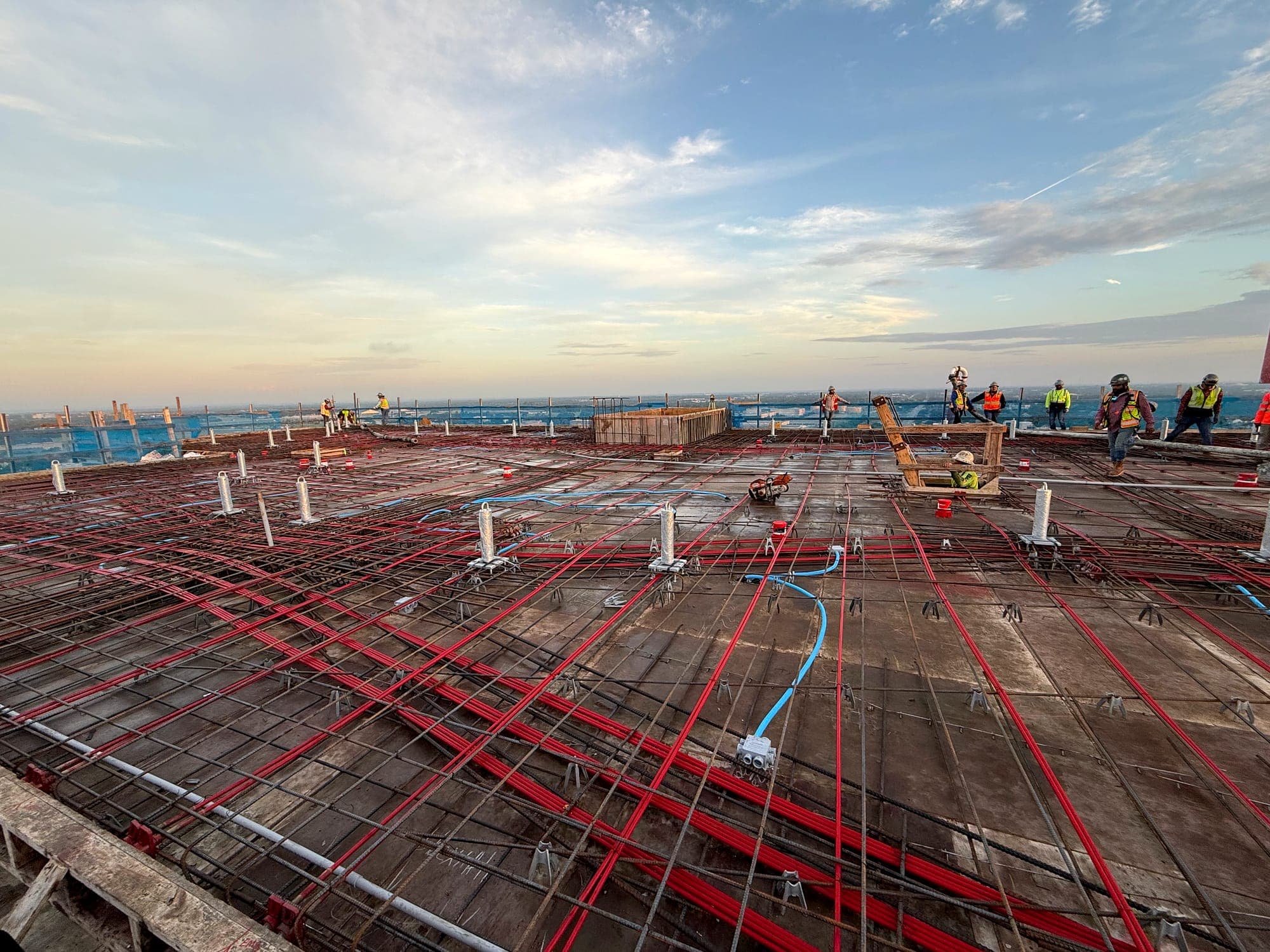Reinforcing steel laid out across an elevated concrete deck at sunset