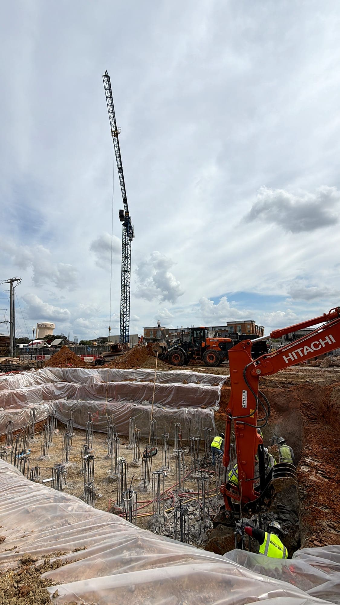 Excavator working a shored foundation excavation on a commercial site