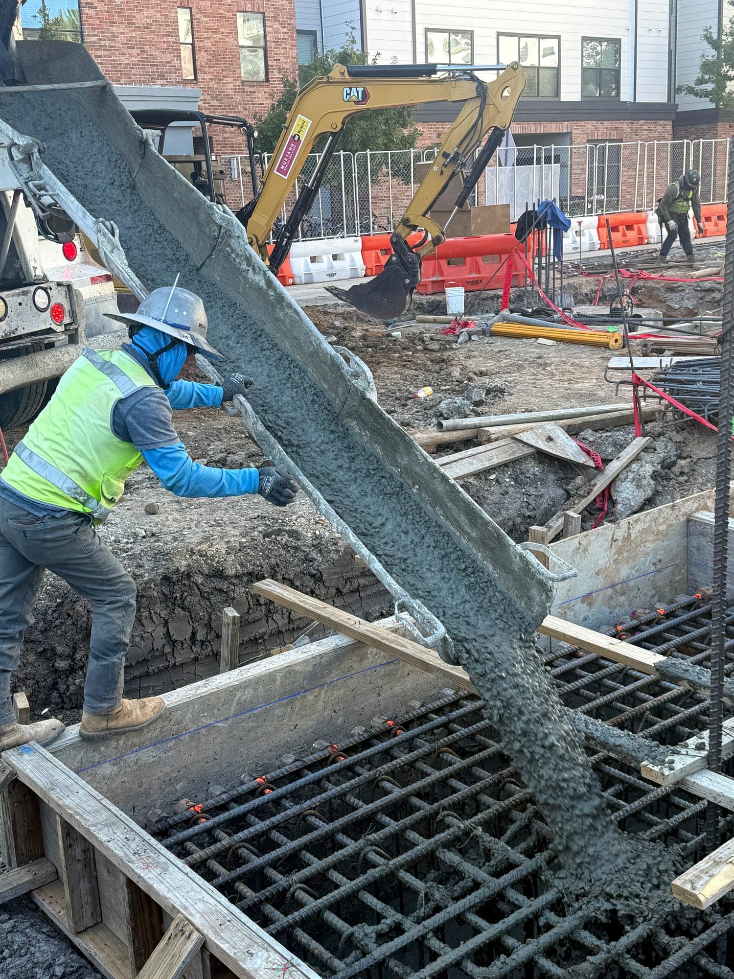 Crew member guiding concrete from the chute during placement