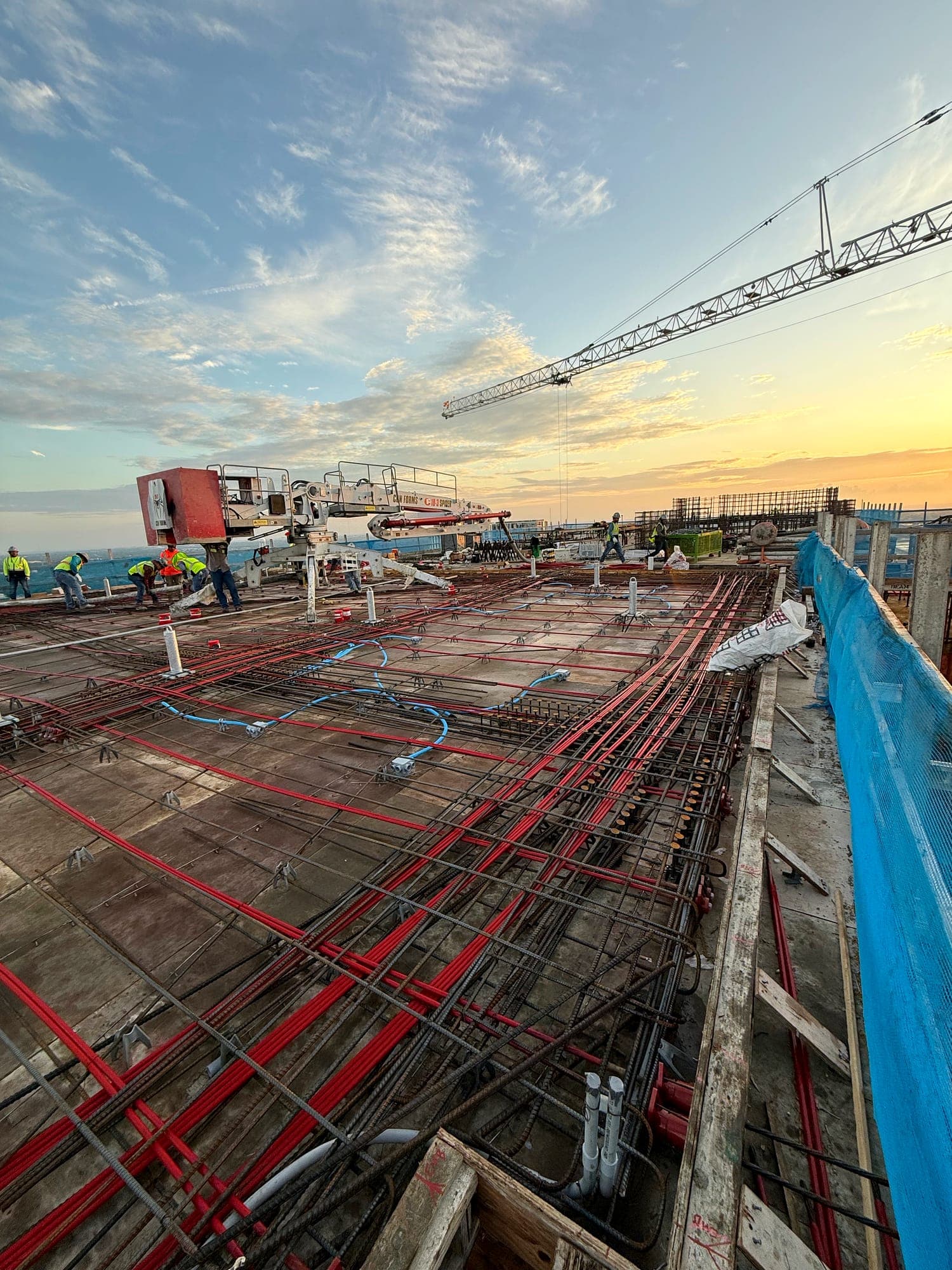 Post-tension cables and reinforcement across a structural deck with tower crane overhead