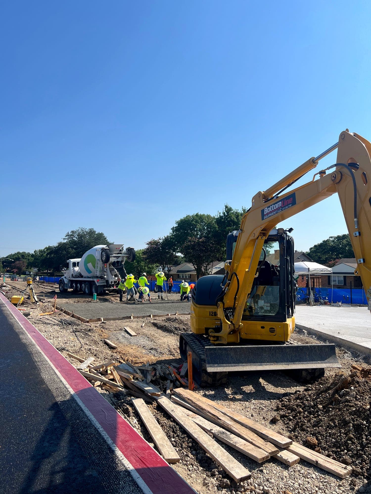 Excavator and mixer truck working a roadway concrete section