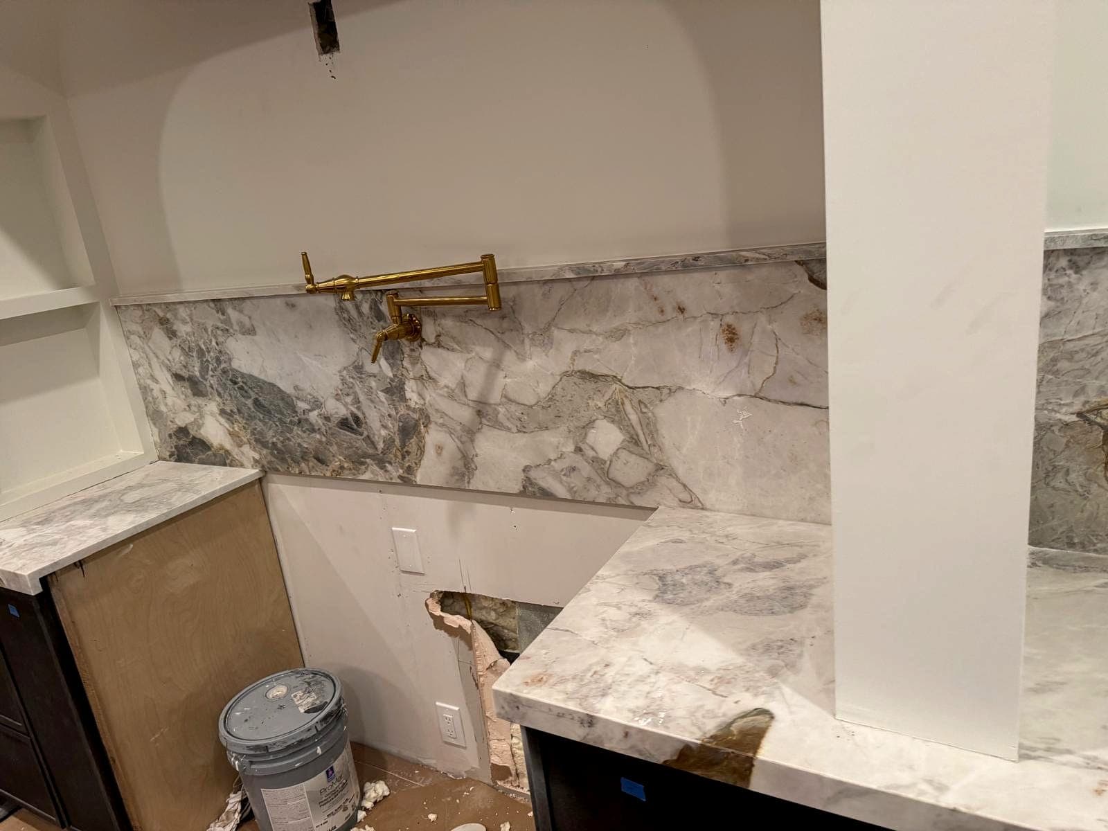 Full-height stone backsplash with pot filler installed behind the range wall