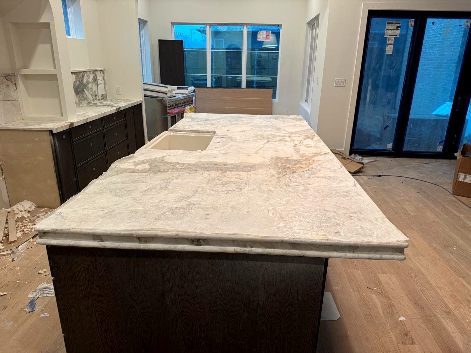 Stone island top installed in an open-plan kitchen during finish work