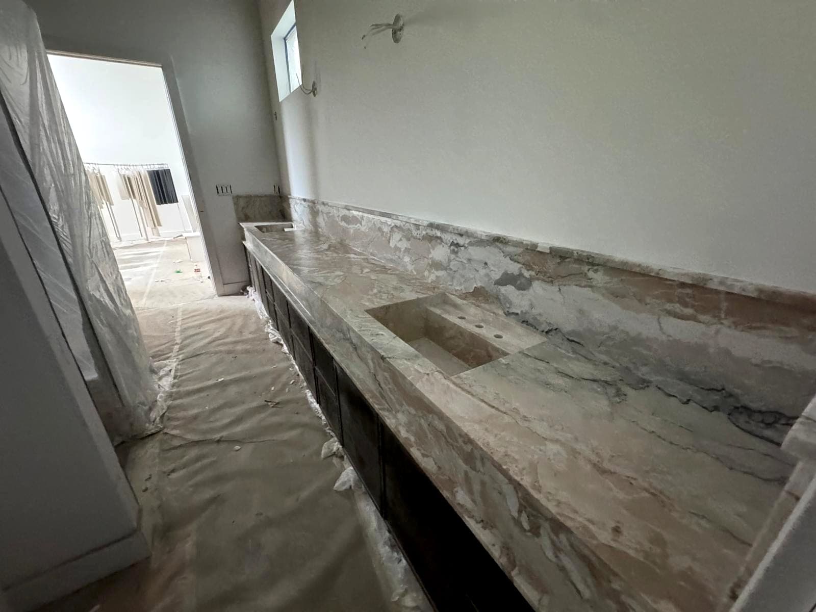 Extended stone counter run installed with protected flooring below