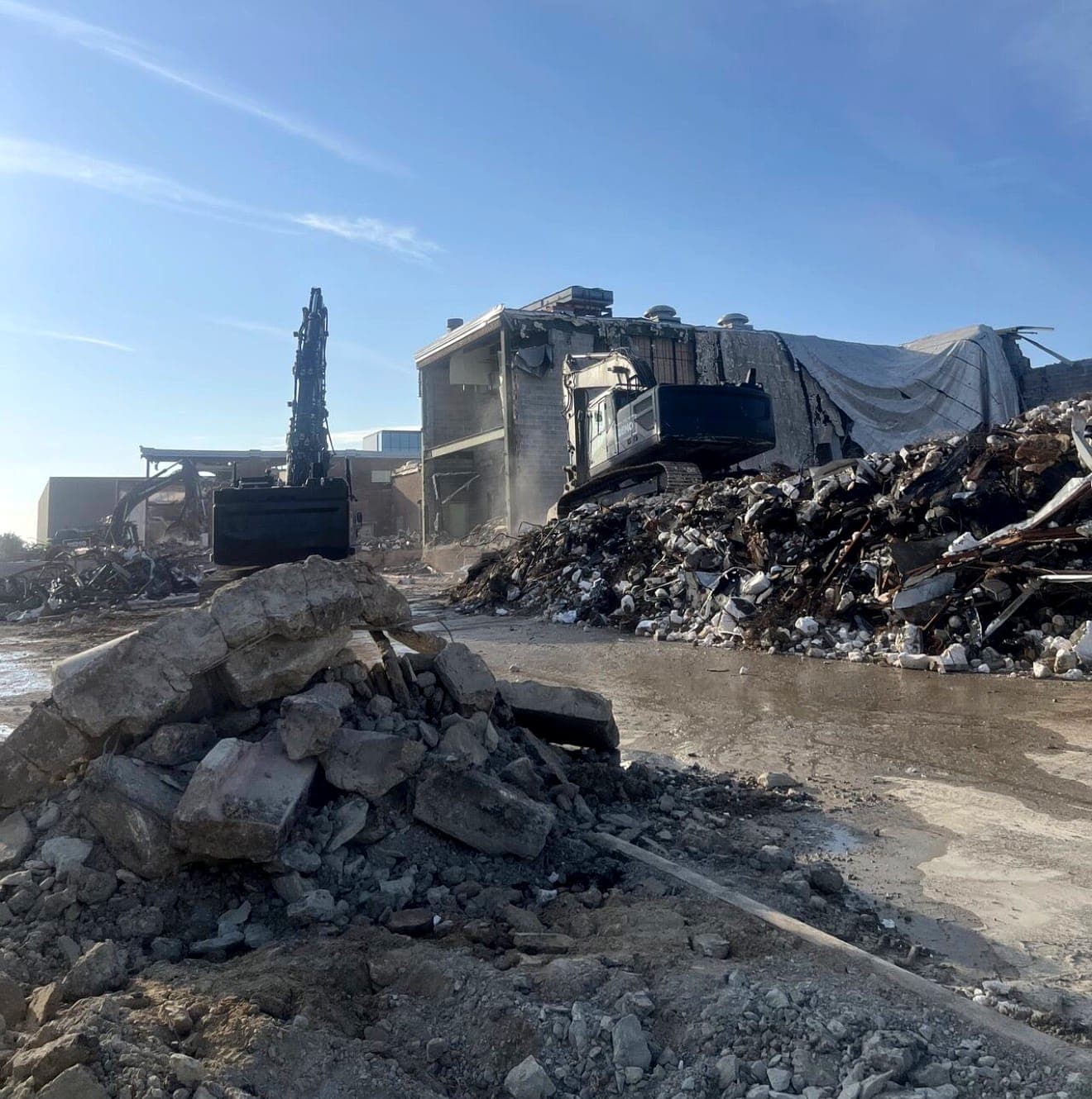 Excavator removing a commercial structure during demolition