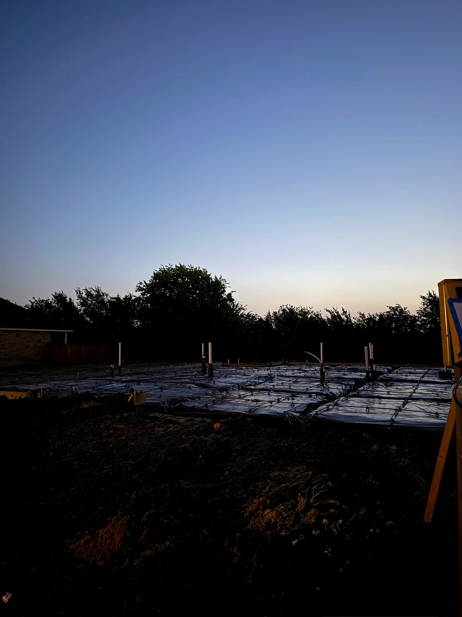 Graded site with formwork and reinforcement set for a slab pour at dusk