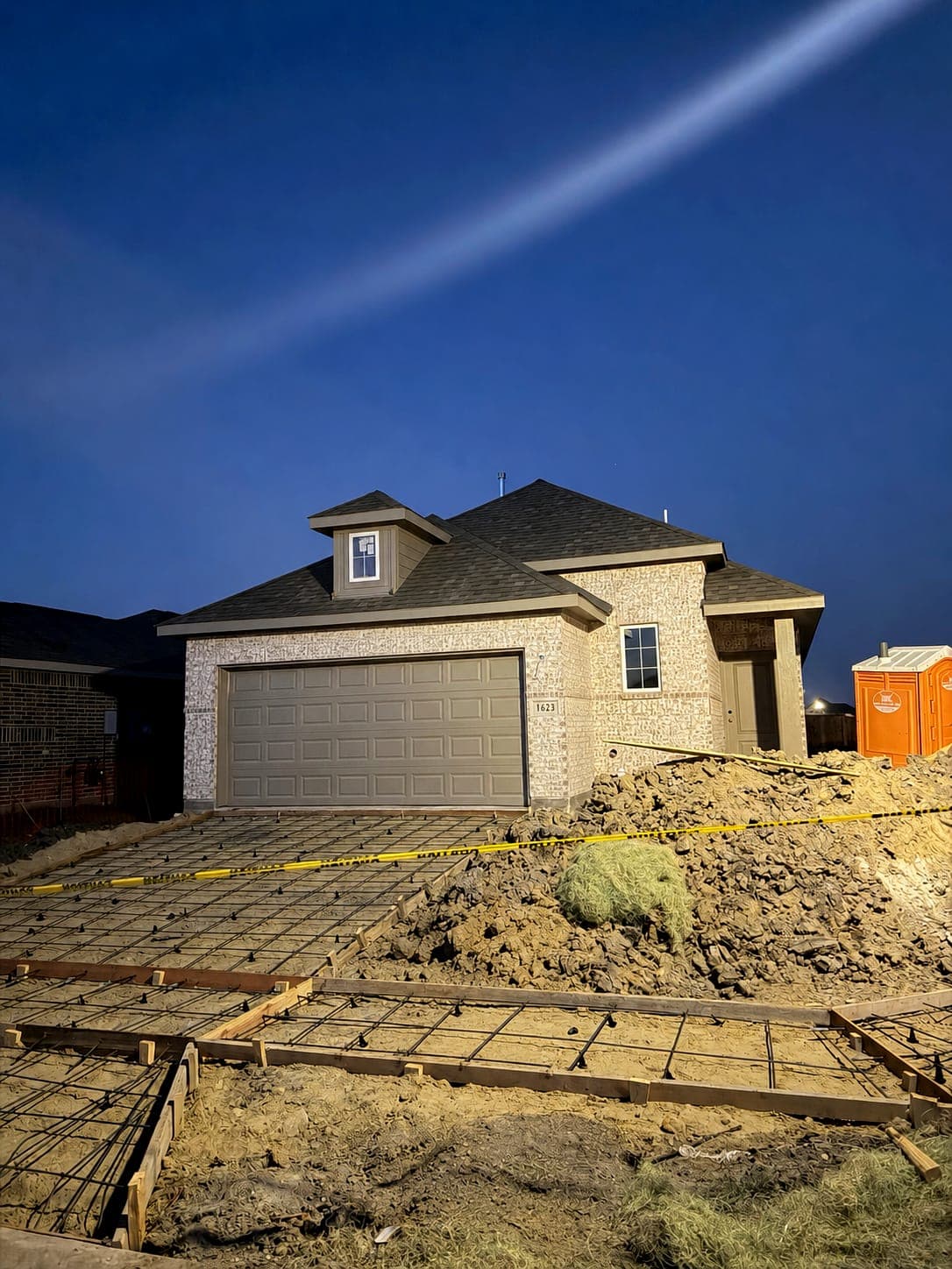 Formed driveway ready for concrete placement at a completed brick home