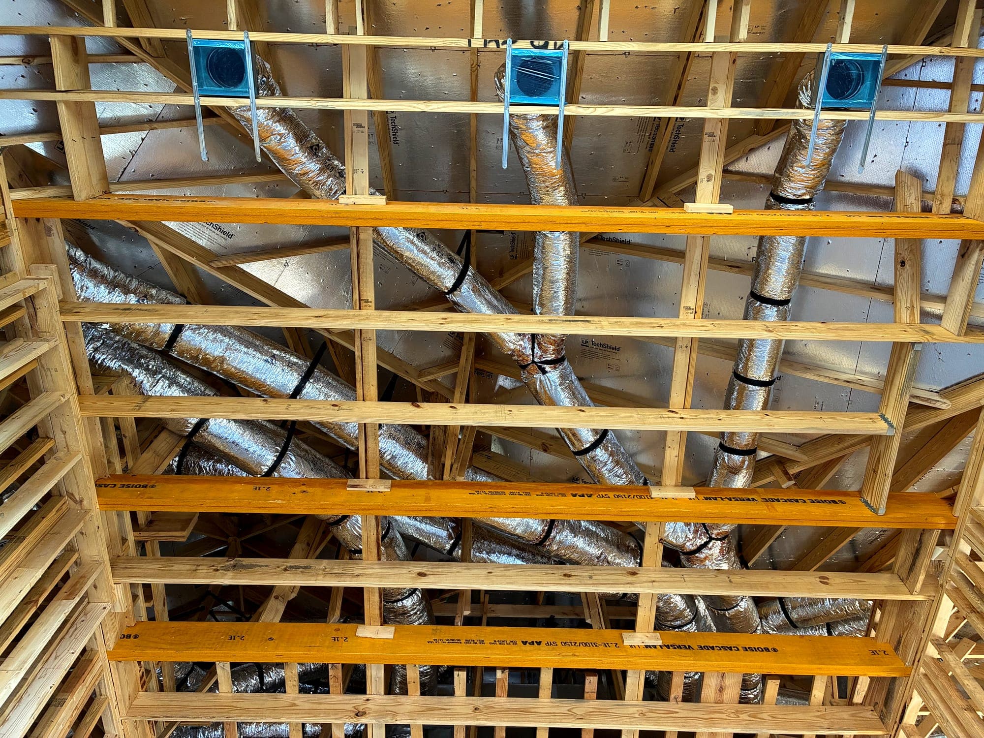 Duct runs and supply boots laid out between ceiling joists