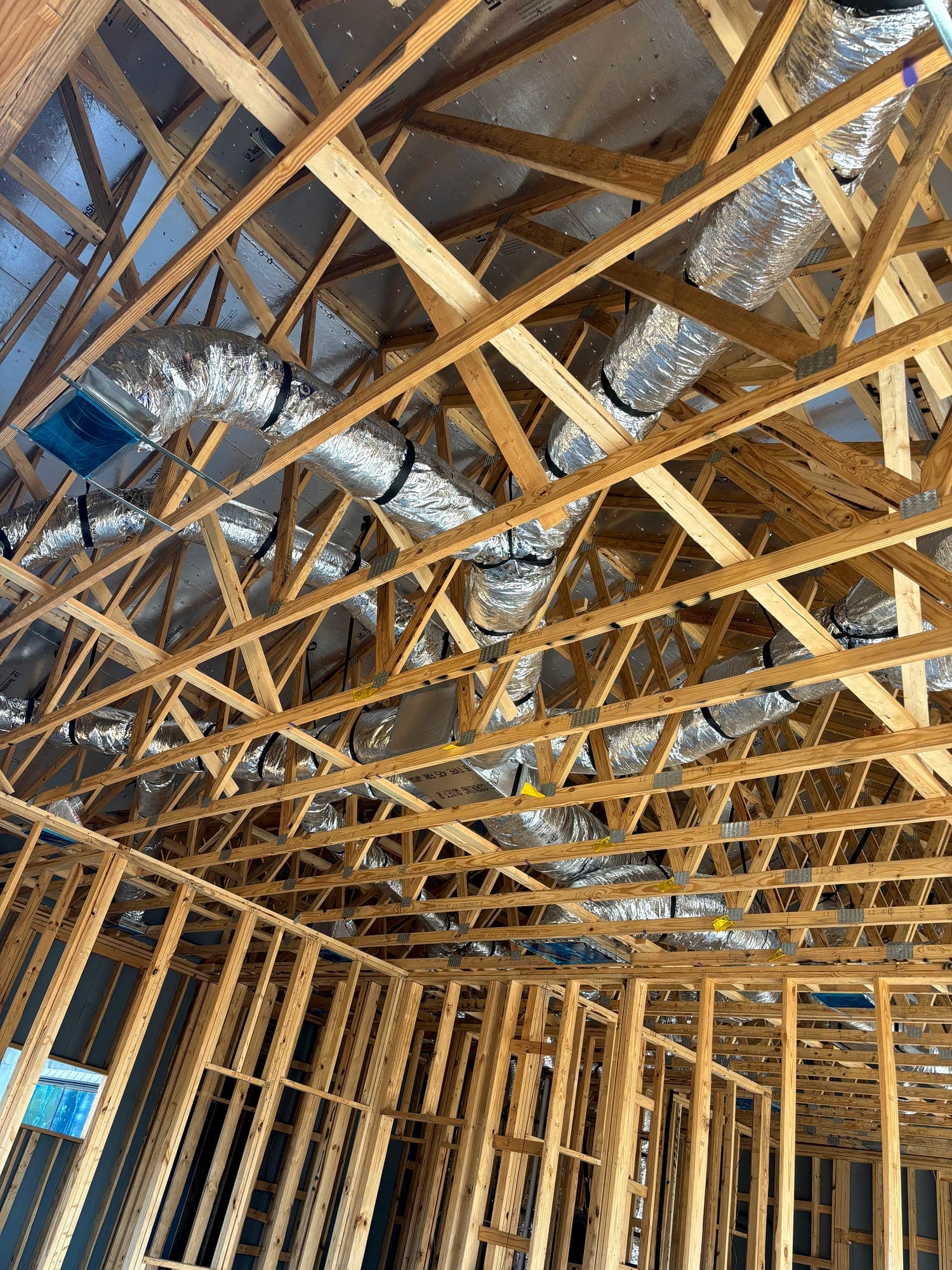 Insulated duct distribution routed through roof trusses