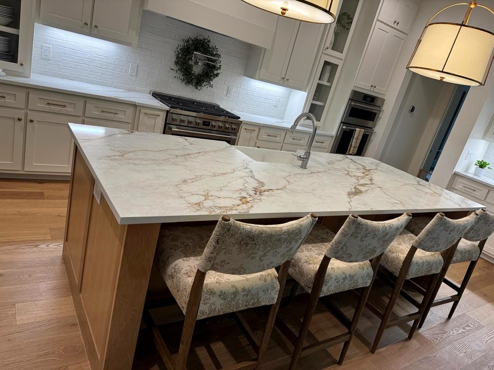 Finished kitchen with a marble-look island, white oak cabinetry and seating