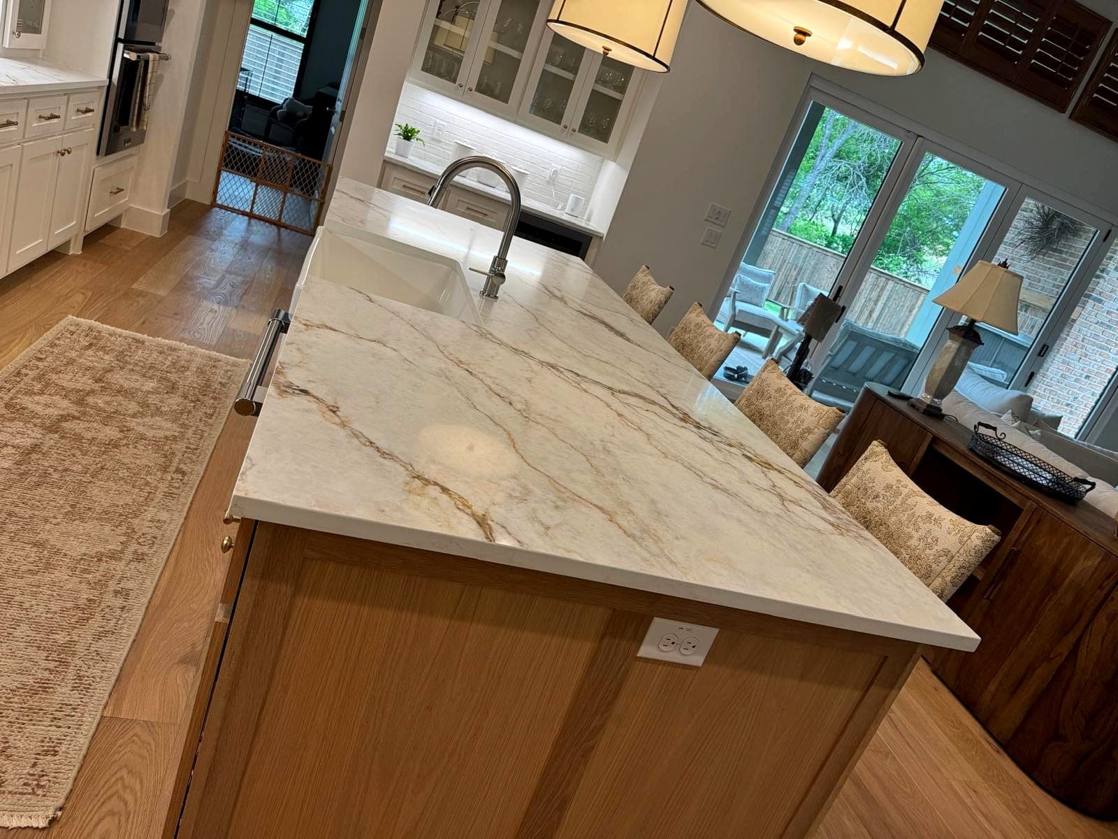 Completed kitchen island with faucet, white oak cabinetry and stone counters