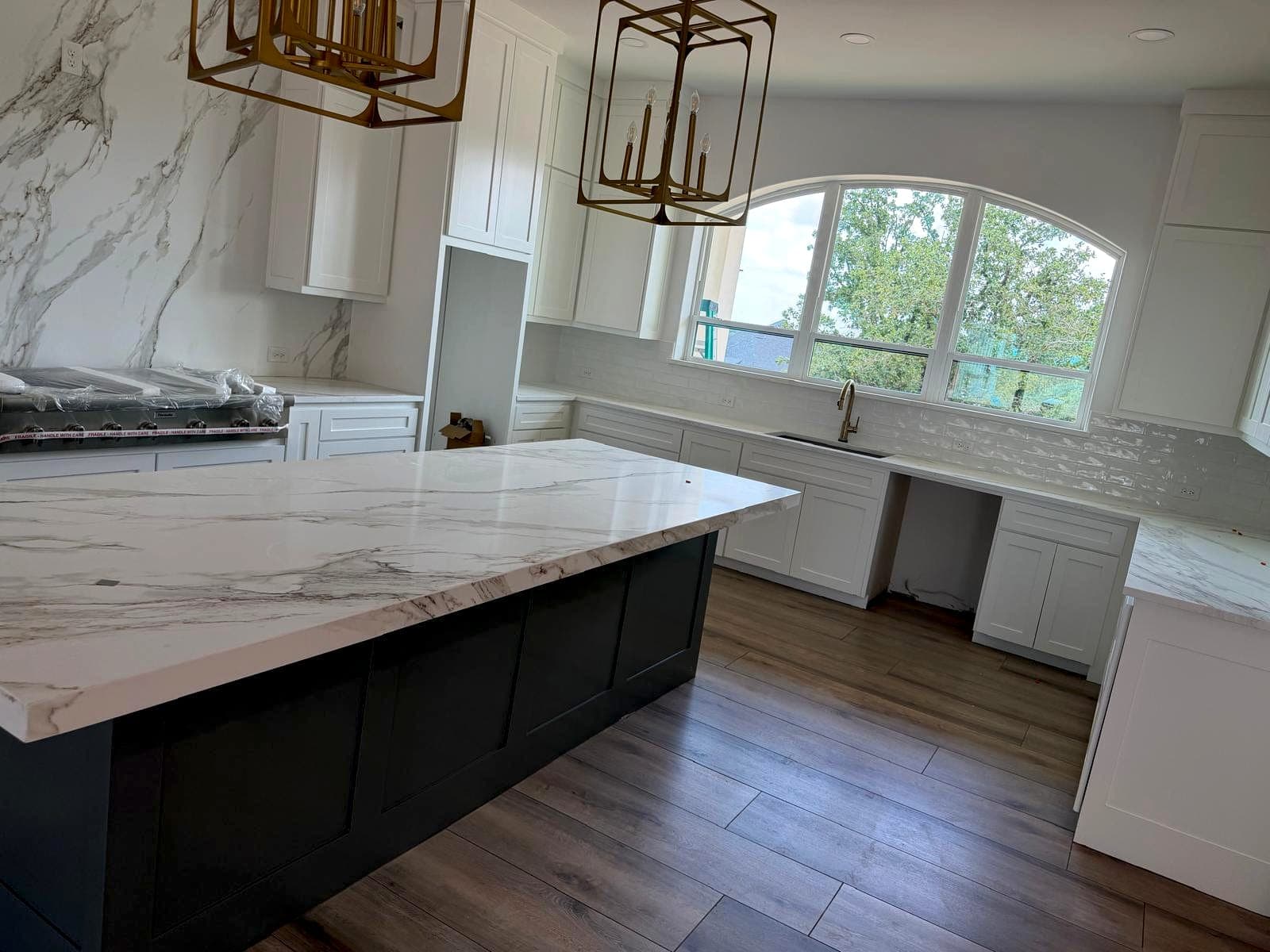 Large kitchen with stone island, perimeter counters and pendant lighting