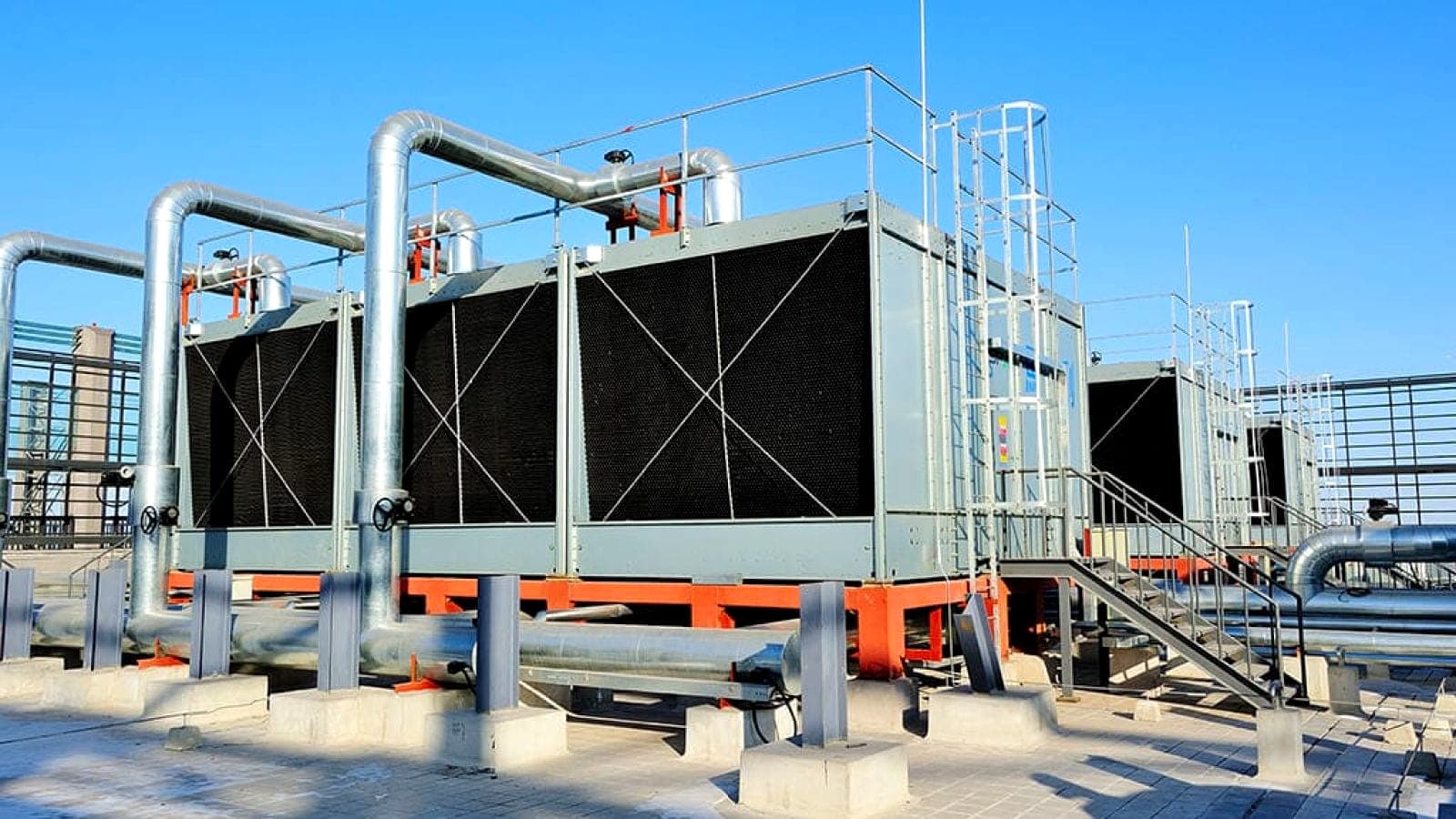 Rooftop cooling towers and header piping on a commercial mechanical system