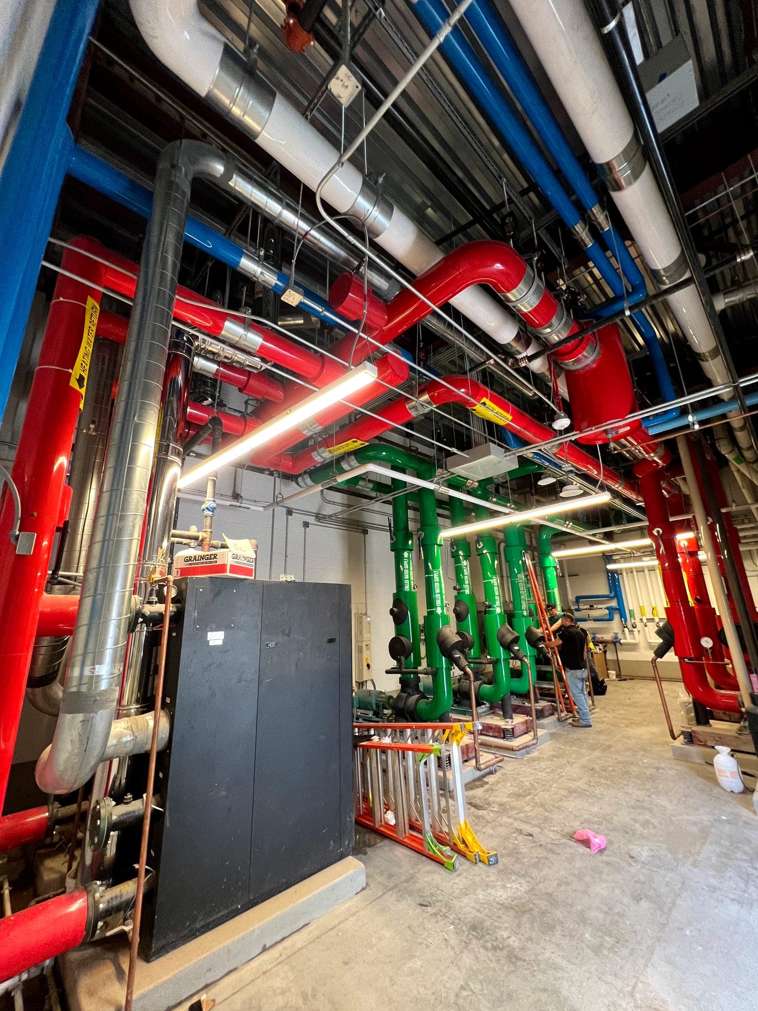 Commercial mechanical room with color-coded process piping and equipment