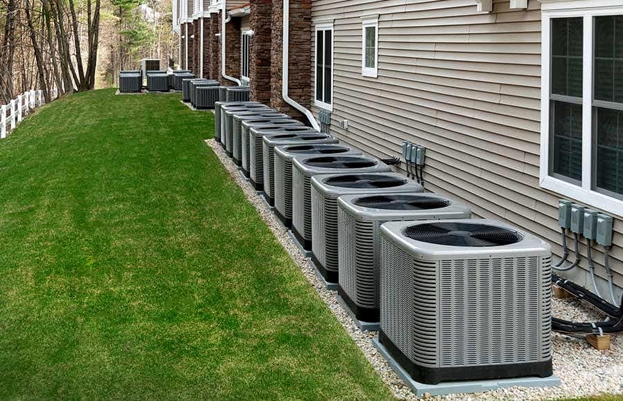 Row of condensing units installed along a multifamily building