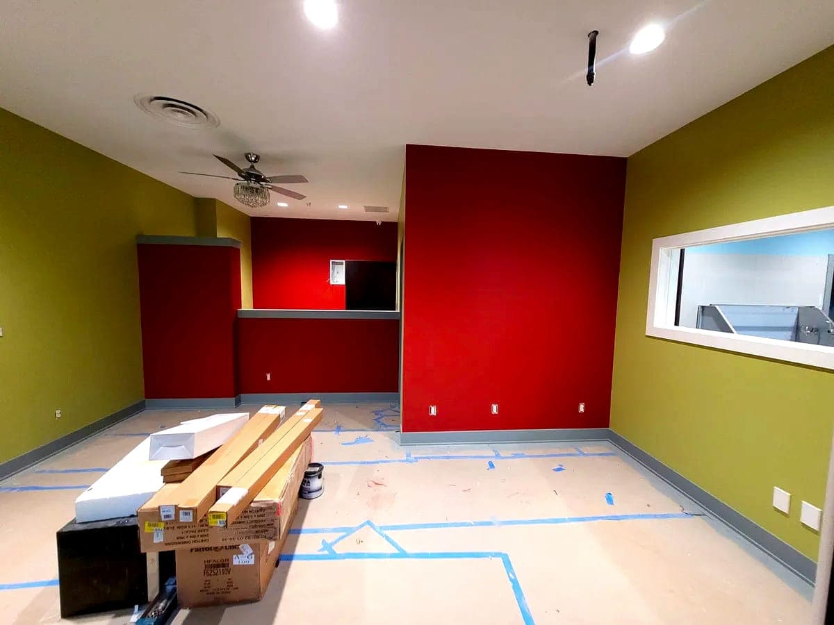 Commercial interior with painted accent walls, masked trim and protected flooring