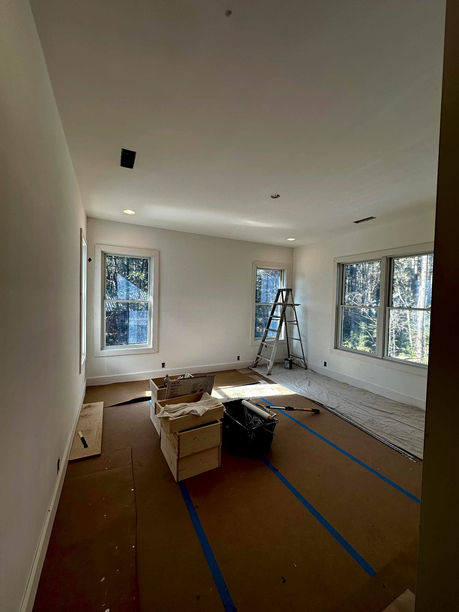 Interior painting underway with drop cloths and full floor protection in place