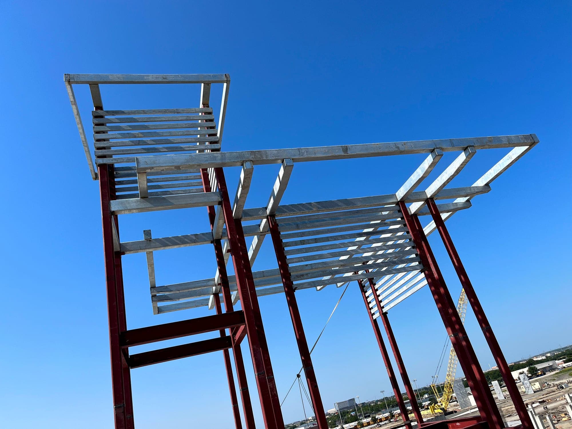 Galvanized steel canopy framing installed on painted structural columns