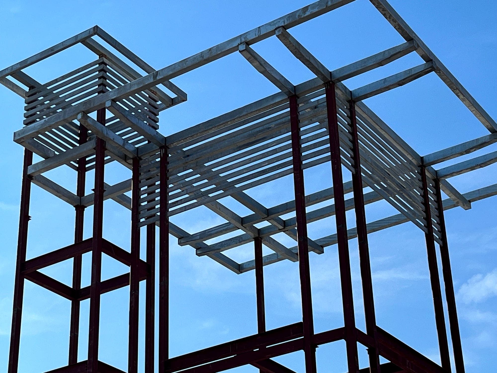 Galvanized canopy structure viewed from below during installation