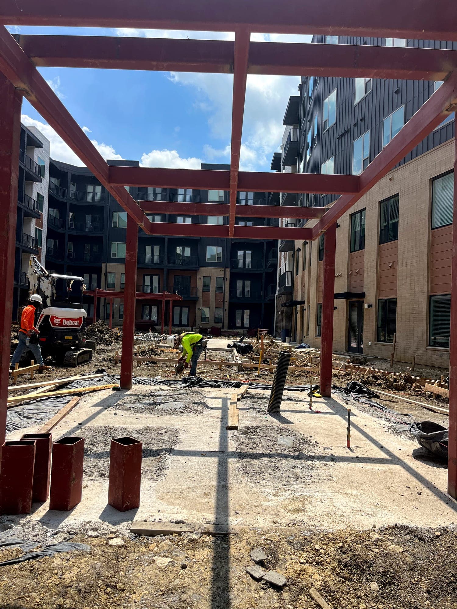 Steel columns and beams set on new foundations in a building courtyard
