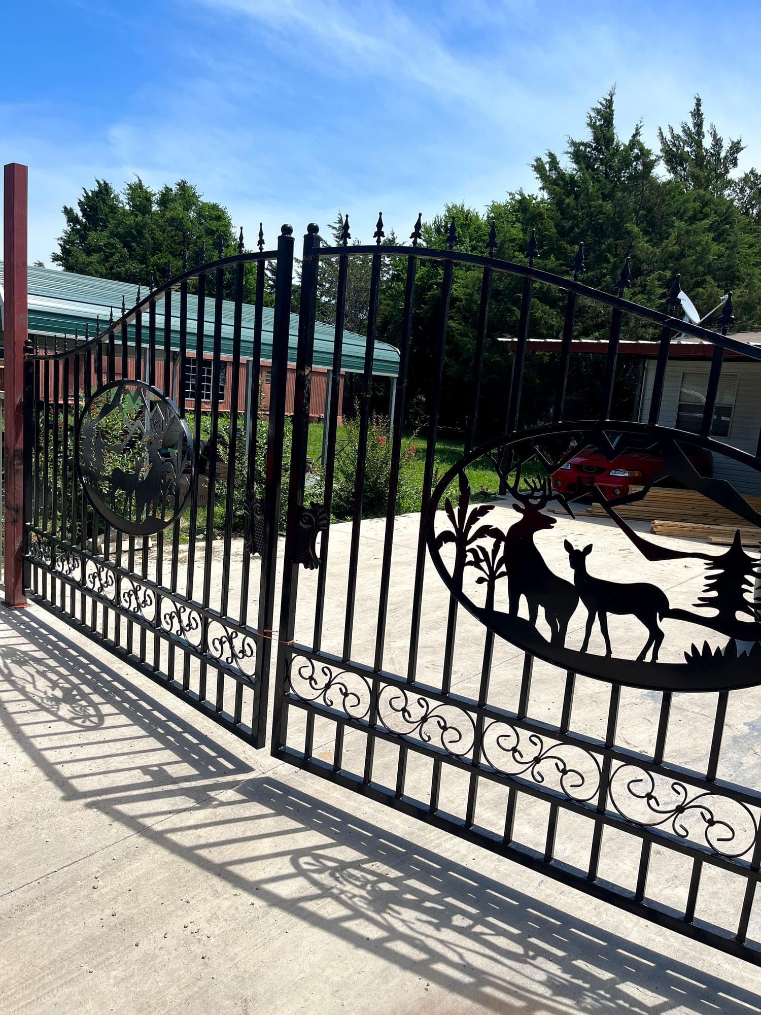Driveway gate with custom-cut steel panel detailing