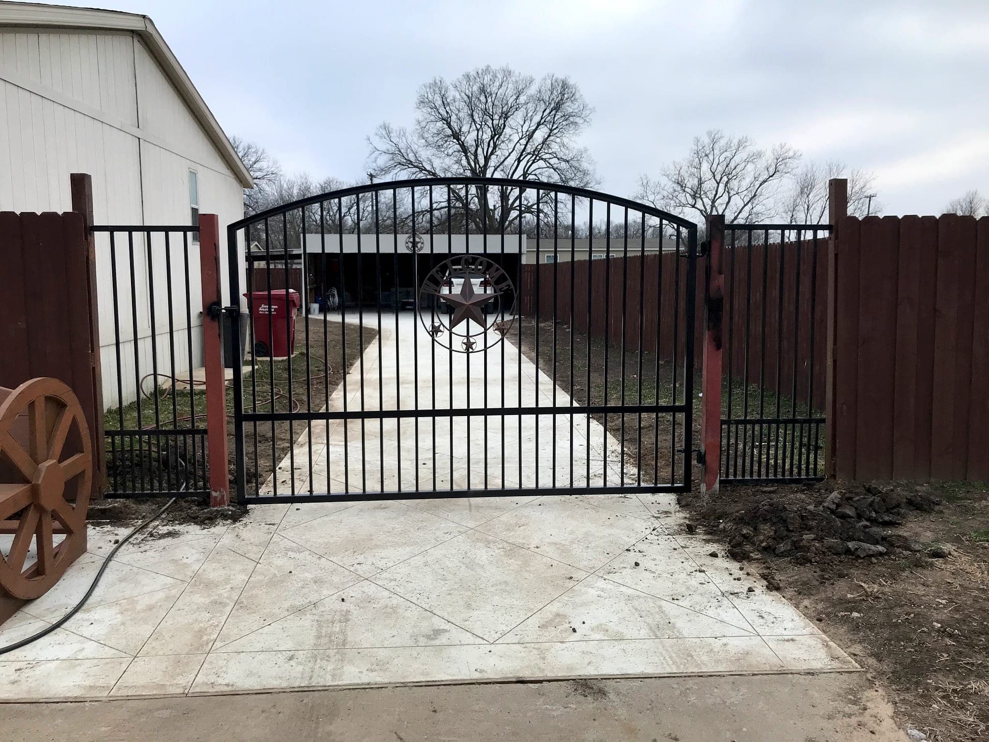 Ornamental steel driveway gate installed between masonry columns