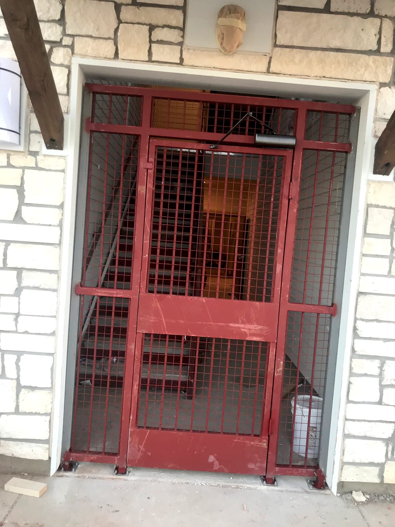 Fabricated steel gate and screen set into a stone building entry