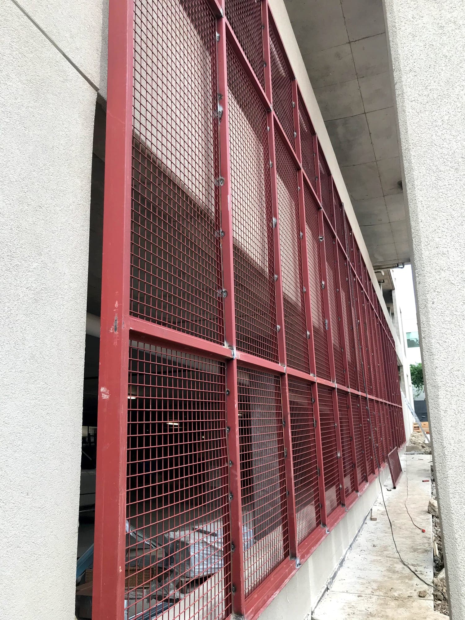 Welded steel mesh screen panels installed along a building facade