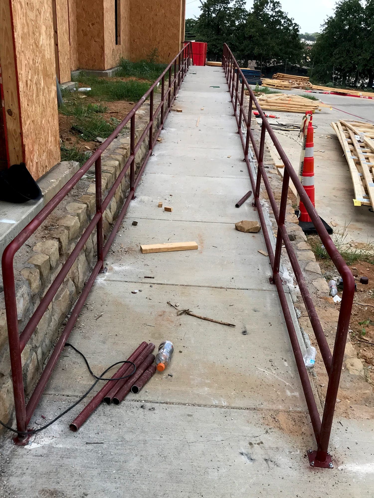 Steel handrail installed along a concrete access ramp