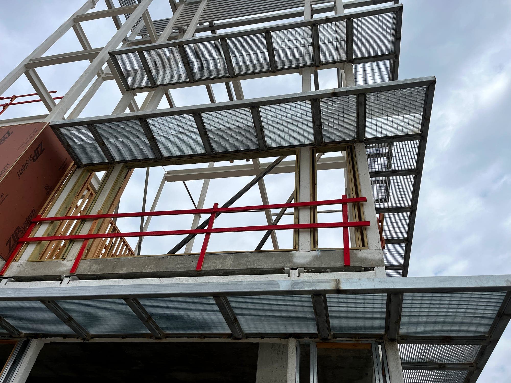 Steel and galvanized grating canopy installed over a building walkway